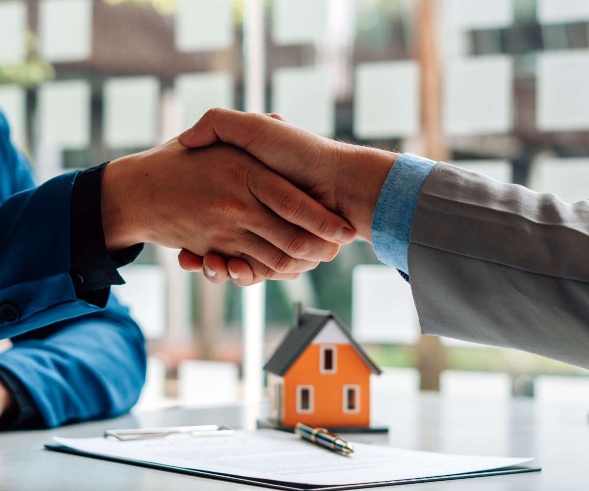 condition suspensive exemple - Un conseiller bancaire serrant la main de son client après avoir signé l'obtention d'un prêt immobilier