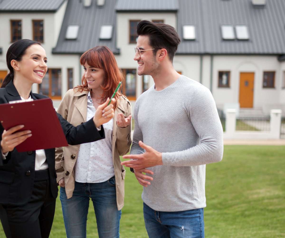consultant immobilier - un agent immobilier en visite d'un lotissement avec un couple d'acquéreurs