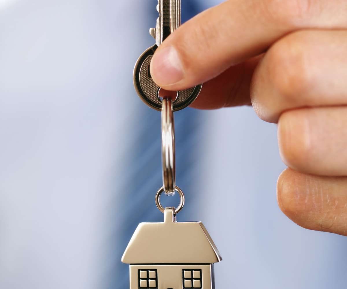 loi hoguet immobilier - un agent immobilier tenant une clé et son porte-clé en forme de maison