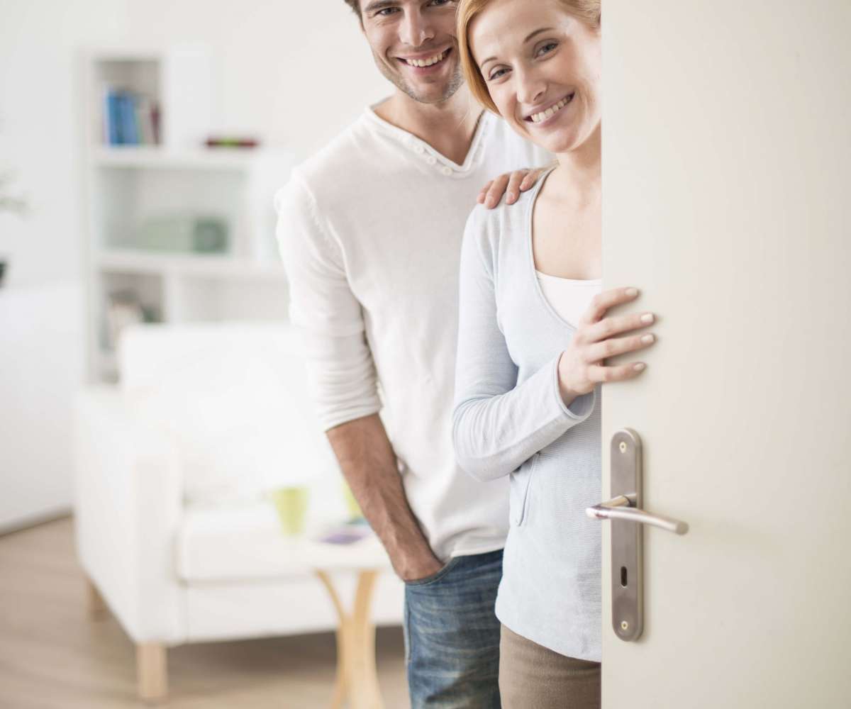 Bon de visite immobilier - un couple ouvre sa porte pour une visite immobilière dans leur appartement