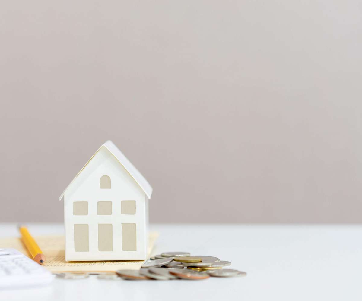 salaire agent immobilier débutant - une maison miniature, de la monnaie et une calculatrice